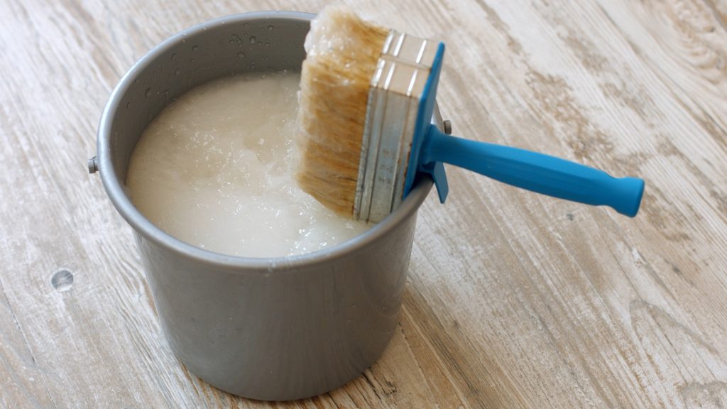 Wallpaper paste brush and grey bucket.